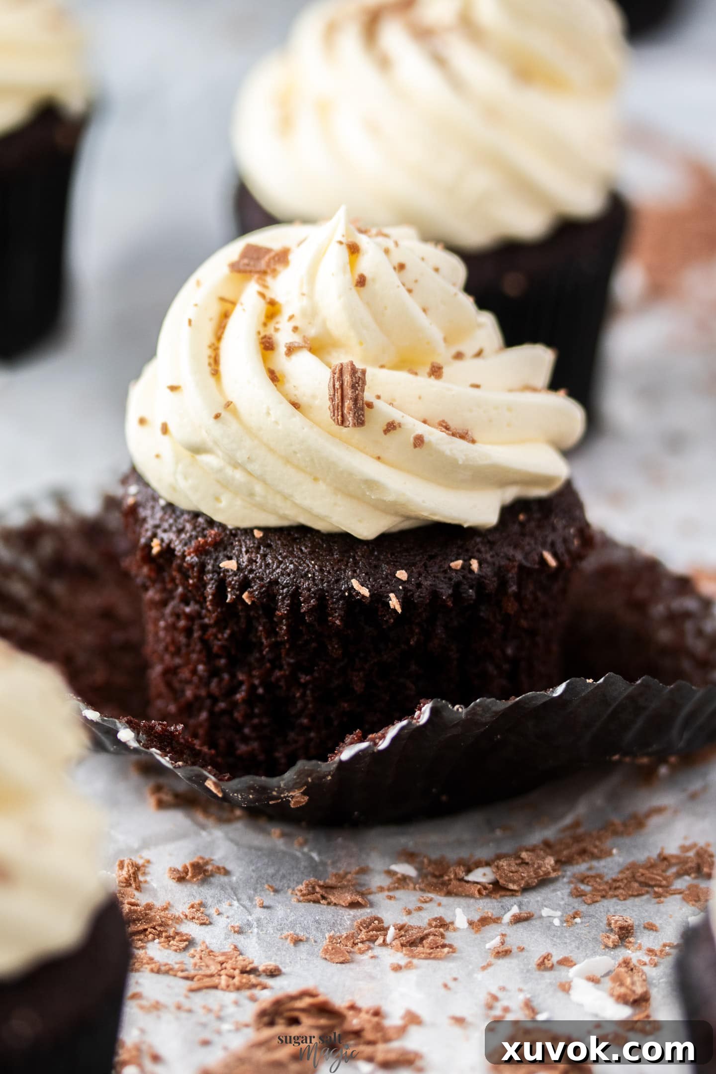 A super close-up shot of a single chocolate mint cupcake, highlighting its moist chocolate crumb, rich ganache filling, and delicate peppermint buttercream swirl, showcasing its irresistible texture and design.