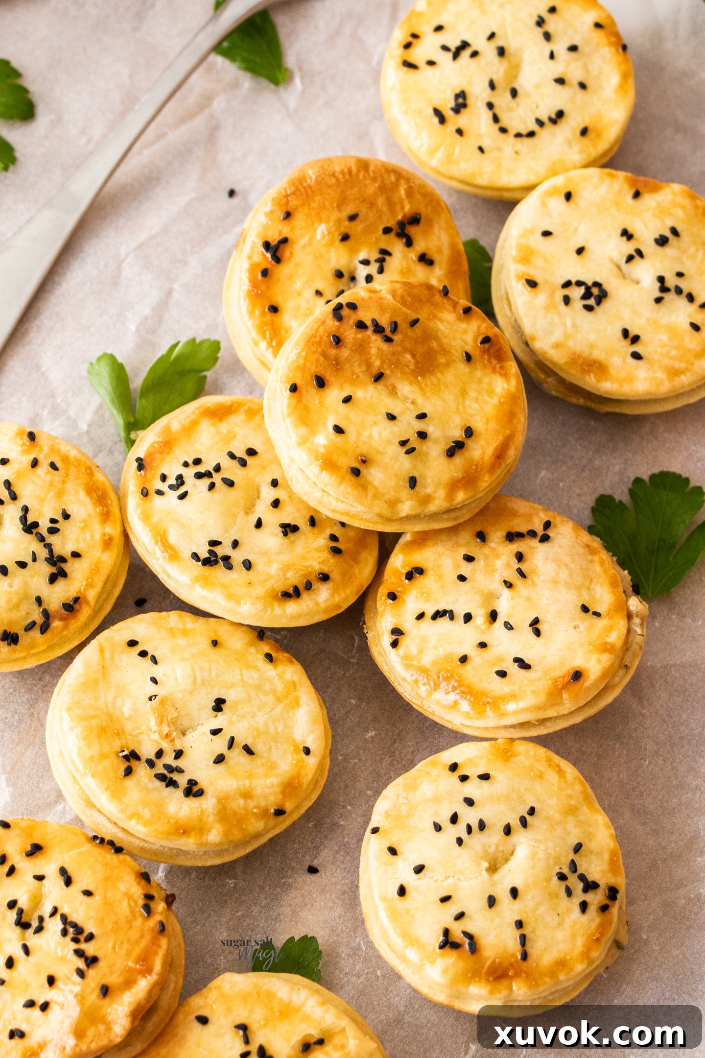 A baking sheet filled with eleven golden-brown mini chicken pot pies, ready to be served as an inviting appetizer or party snack.