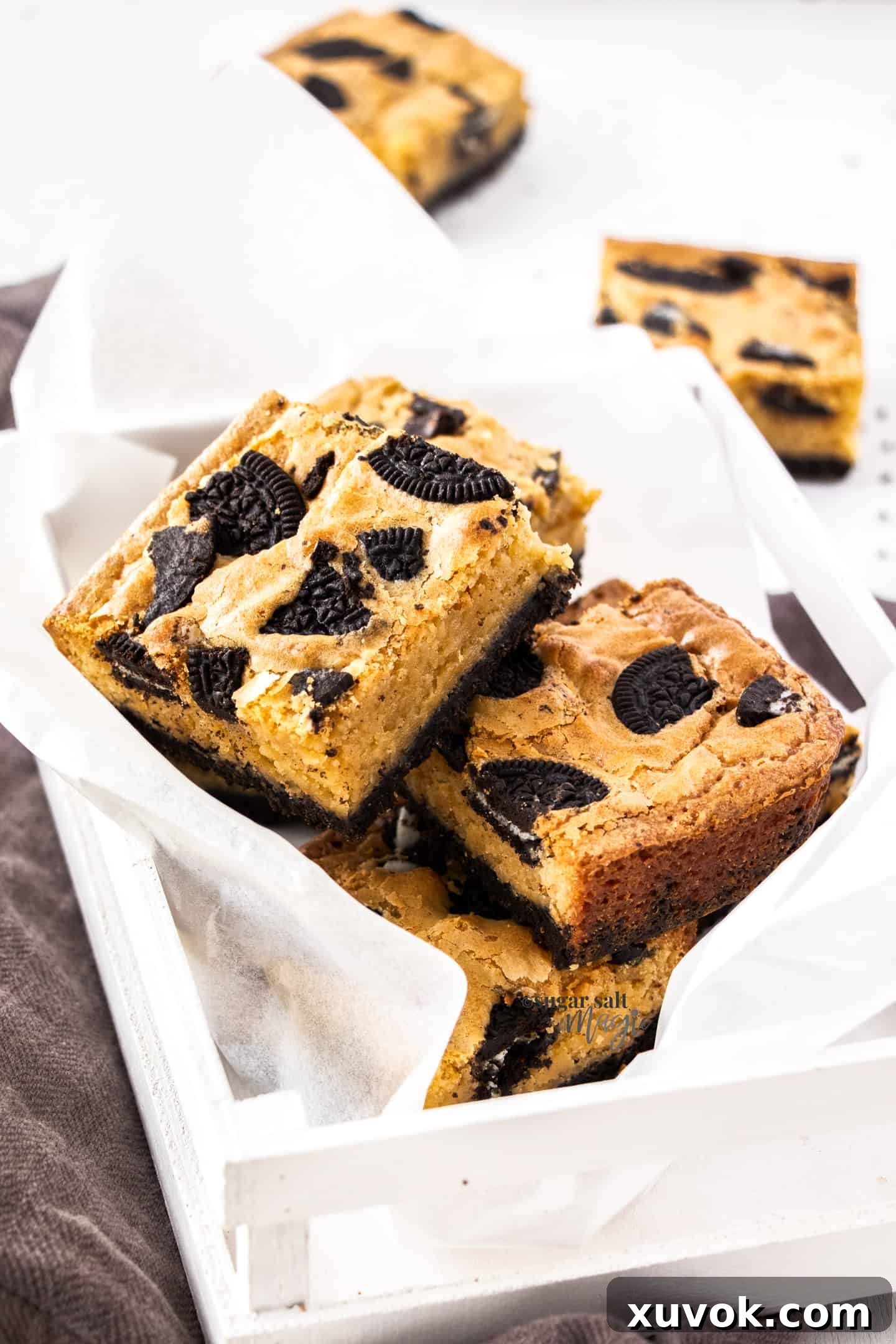 A charming small wooden box filled with an abundance of freshly baked Oreo blondies, ready to be enjoyed or shared, highlighting ideal storage for homemade treats.