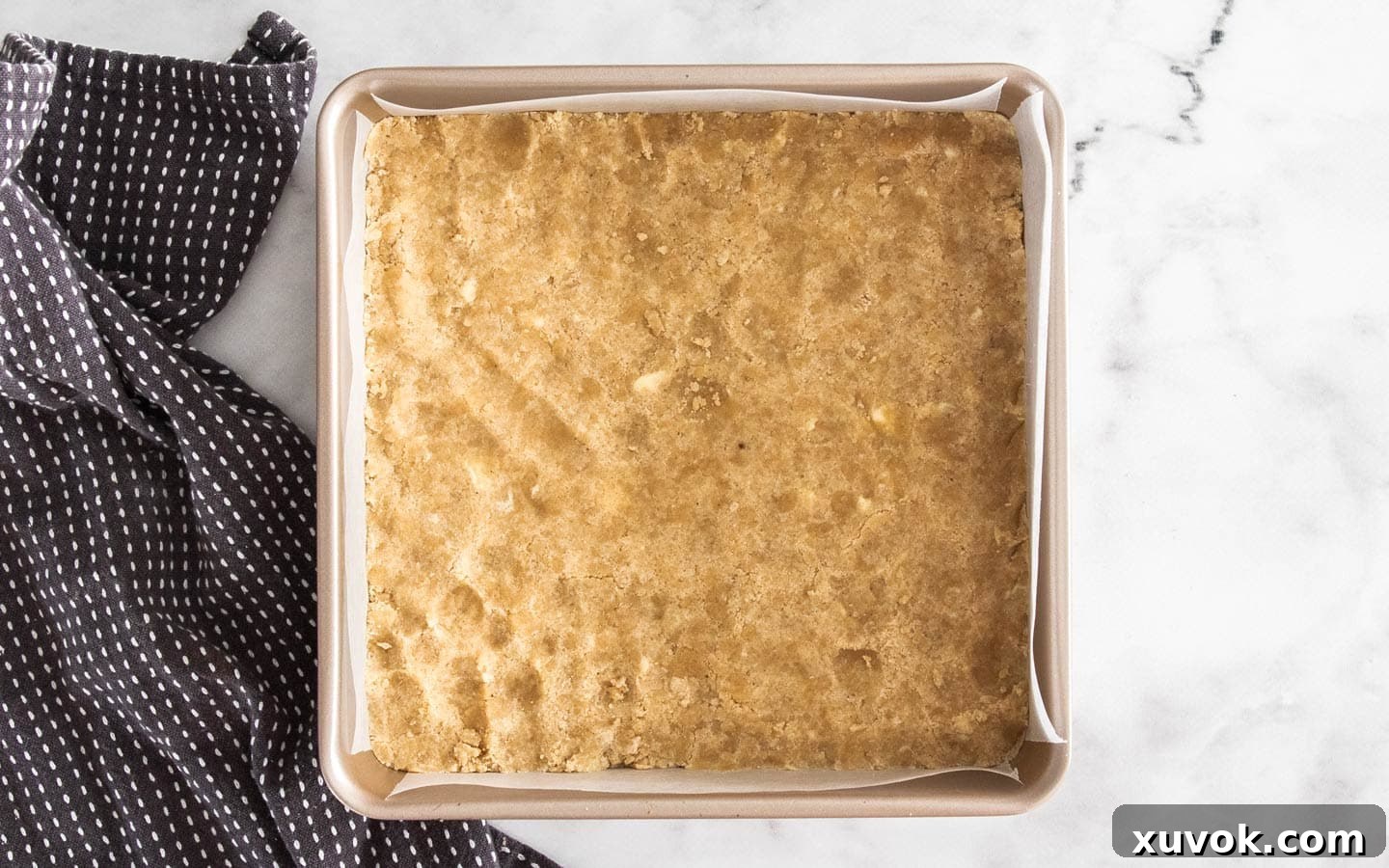 The shortbread base pressed into the baking pan, before its first bake.