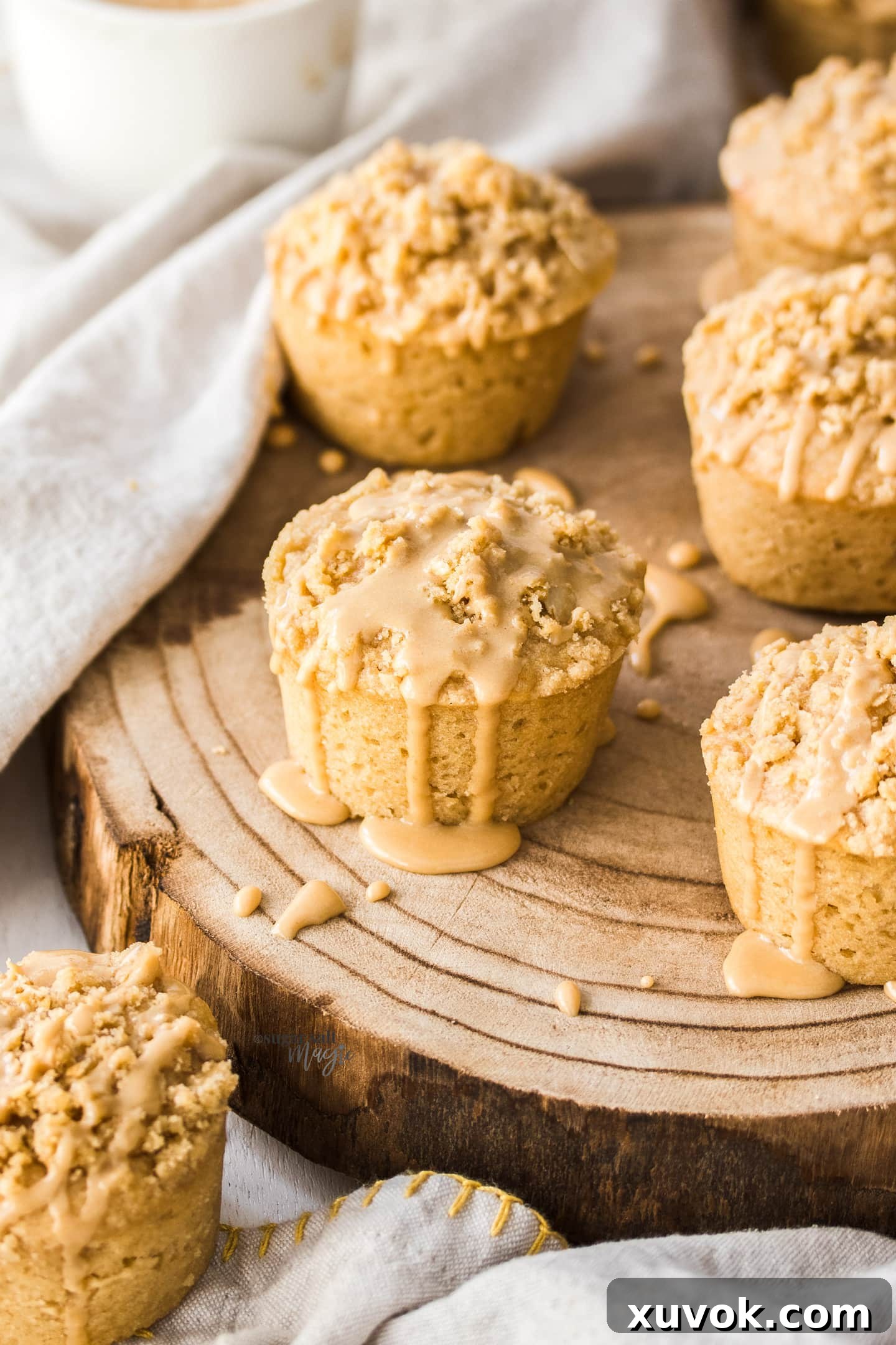 A batch of coffee muffins topped with coffee glaze on a wooden board.