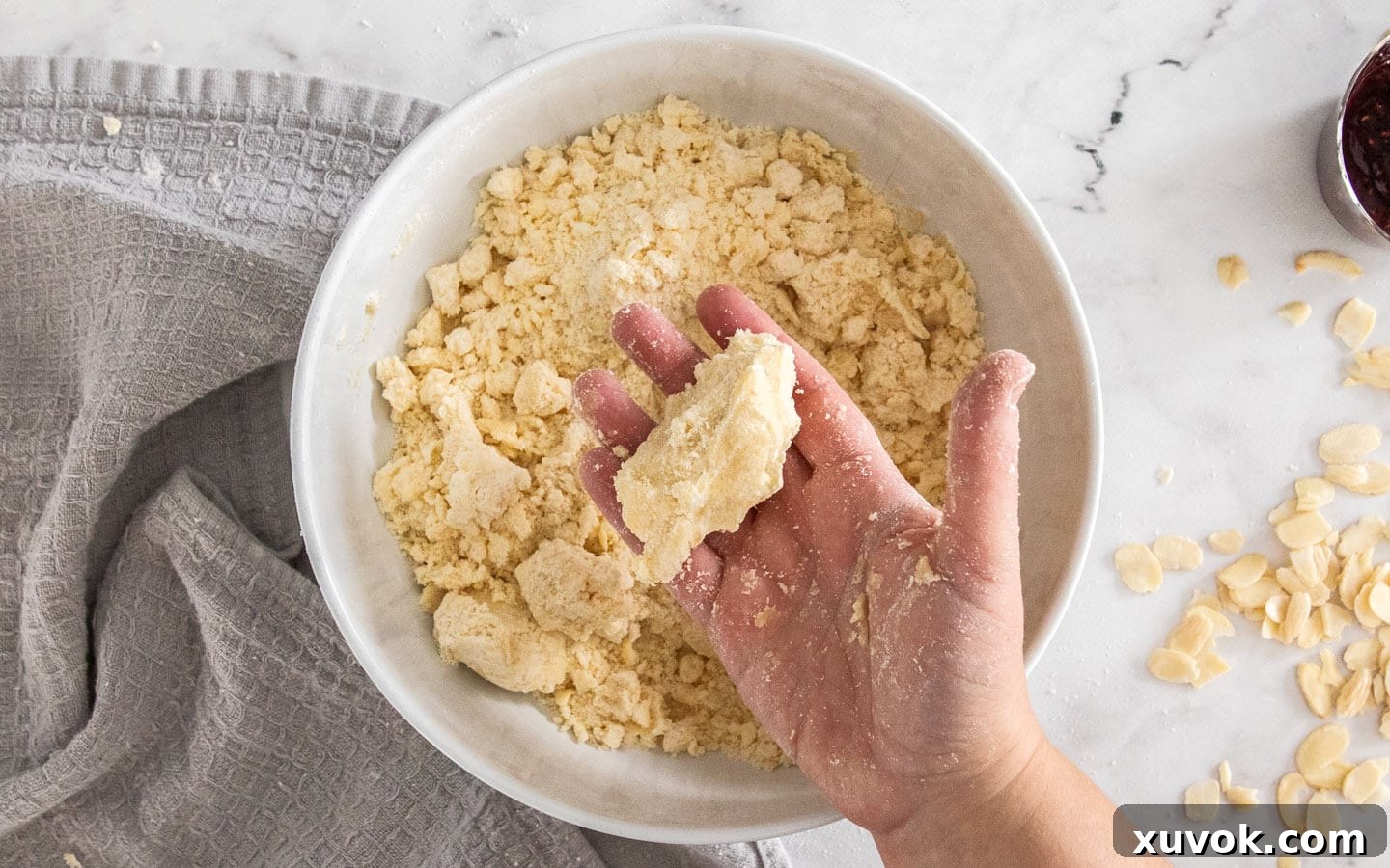 The texture of the shortbread dough after the melted butter has been added, showing it's still crumbly but can hold together.