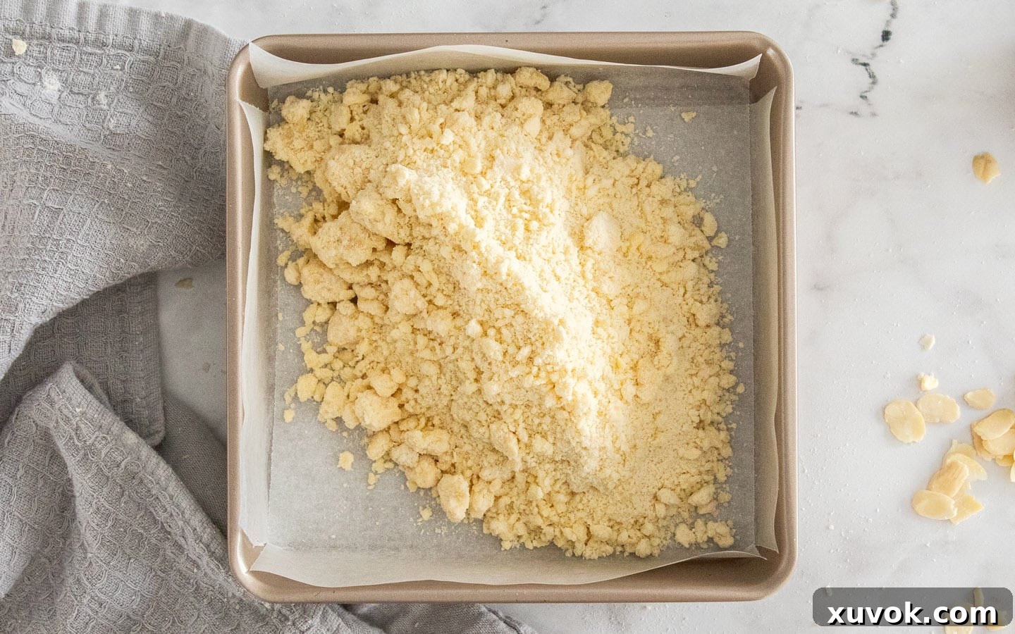 The crumbly shortbread dough in a square baking pan before being pressed.