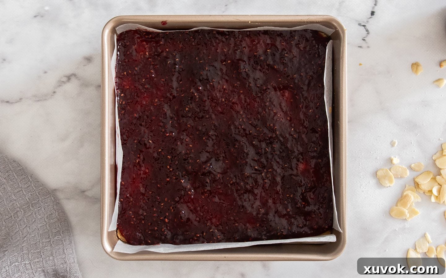 Raspberry jam spread evenly over the pre-baked shortbread base.