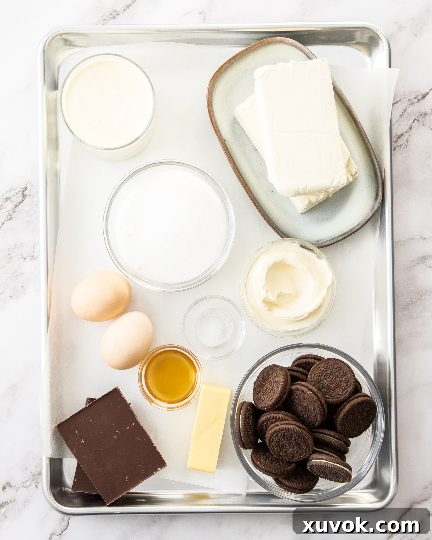 Ingredients for baked chocolate cheesecake on a baking tray.