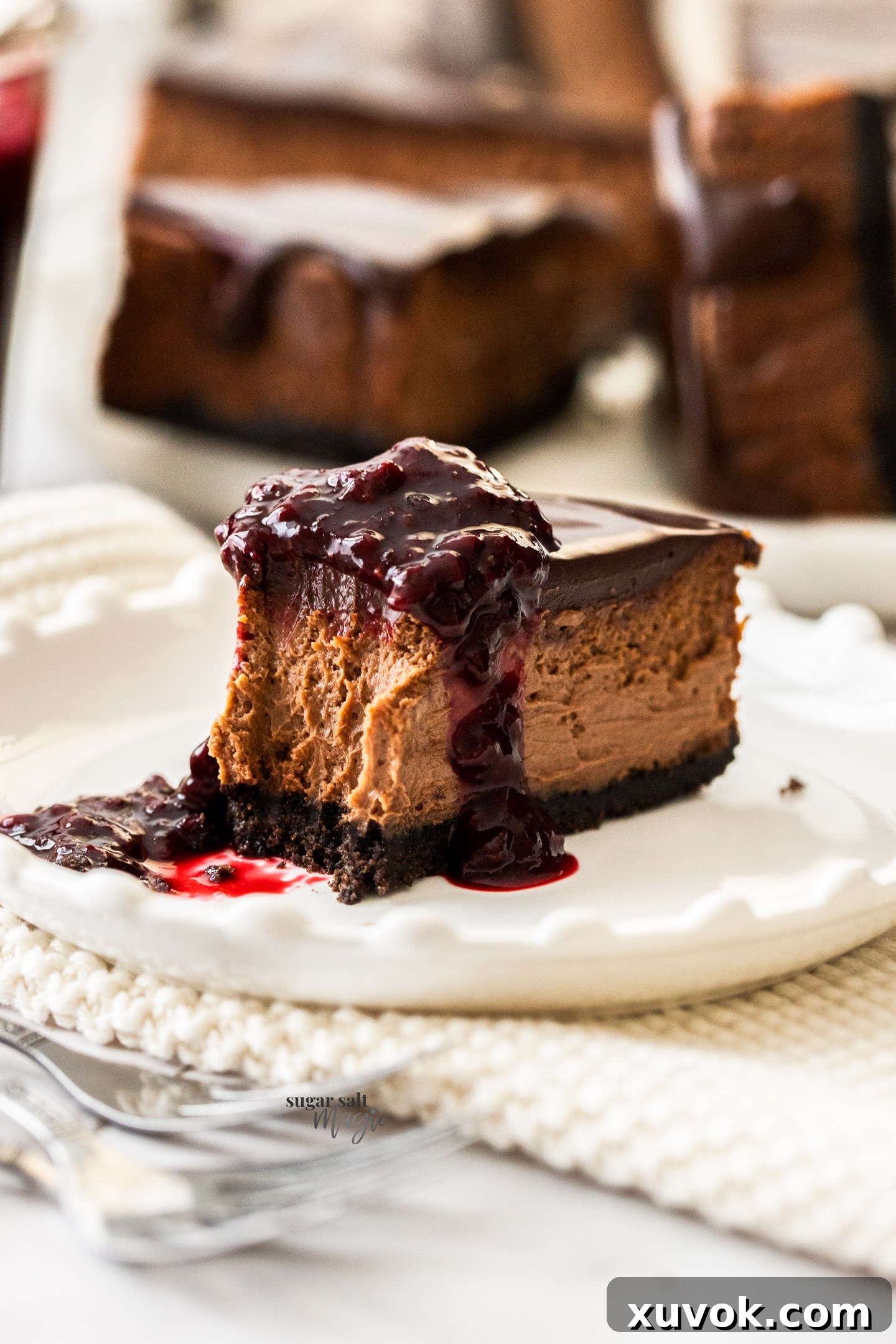 A slice of chocolate cheesecake with a forkful removed.
