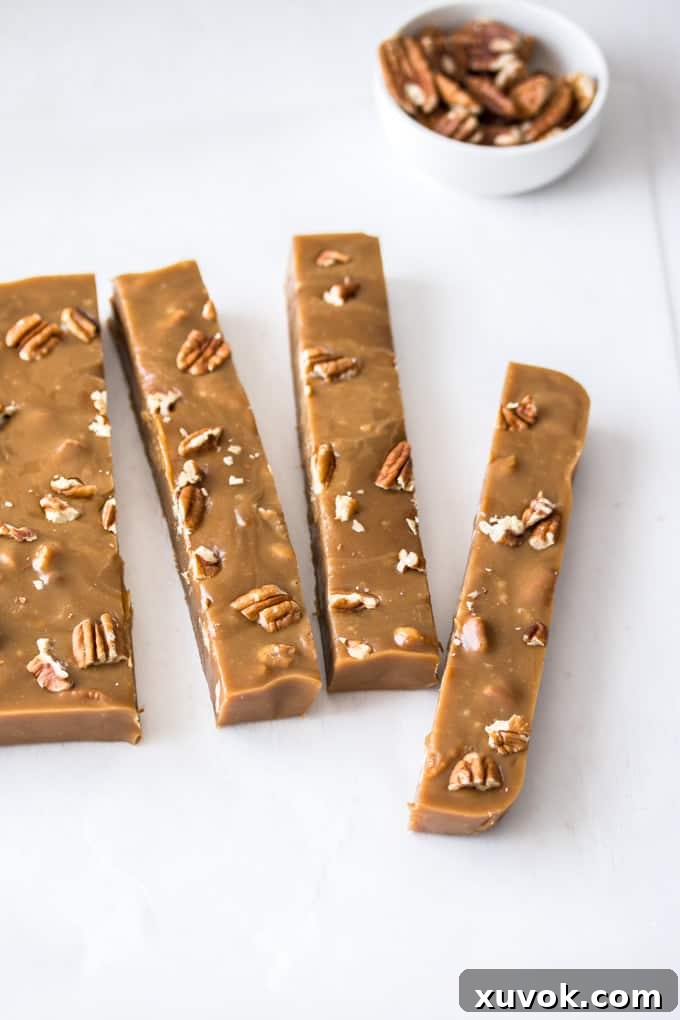 Logs of pecan fudge on a white surface