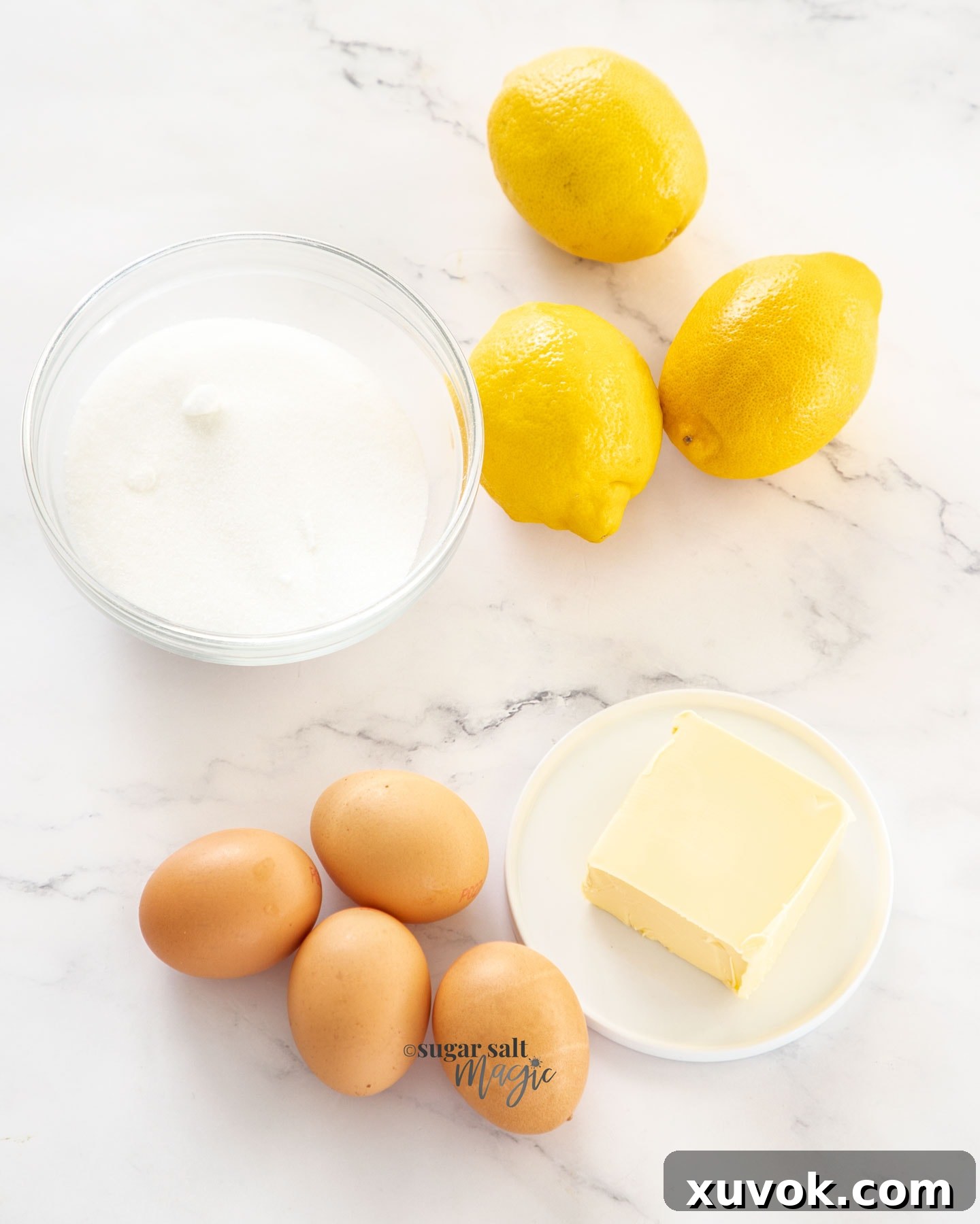 Ingredients for lemon curd on a marble worktop.