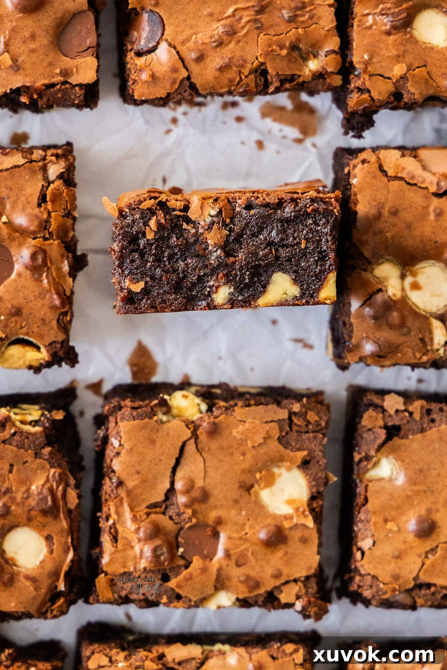 Top down view of chocolate chip brownies with one turned to show the inside, showcasing a fudgy texture and melted chocolate chips.
