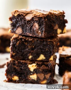 A stack of 3 triple chocolate brownies, showing their rich color and fudgy texture.