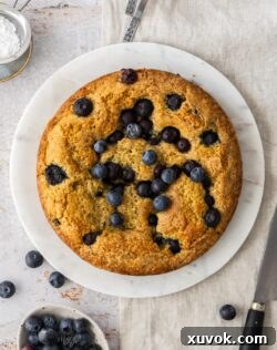 Top down view of a blueberry cake on a marble platter.