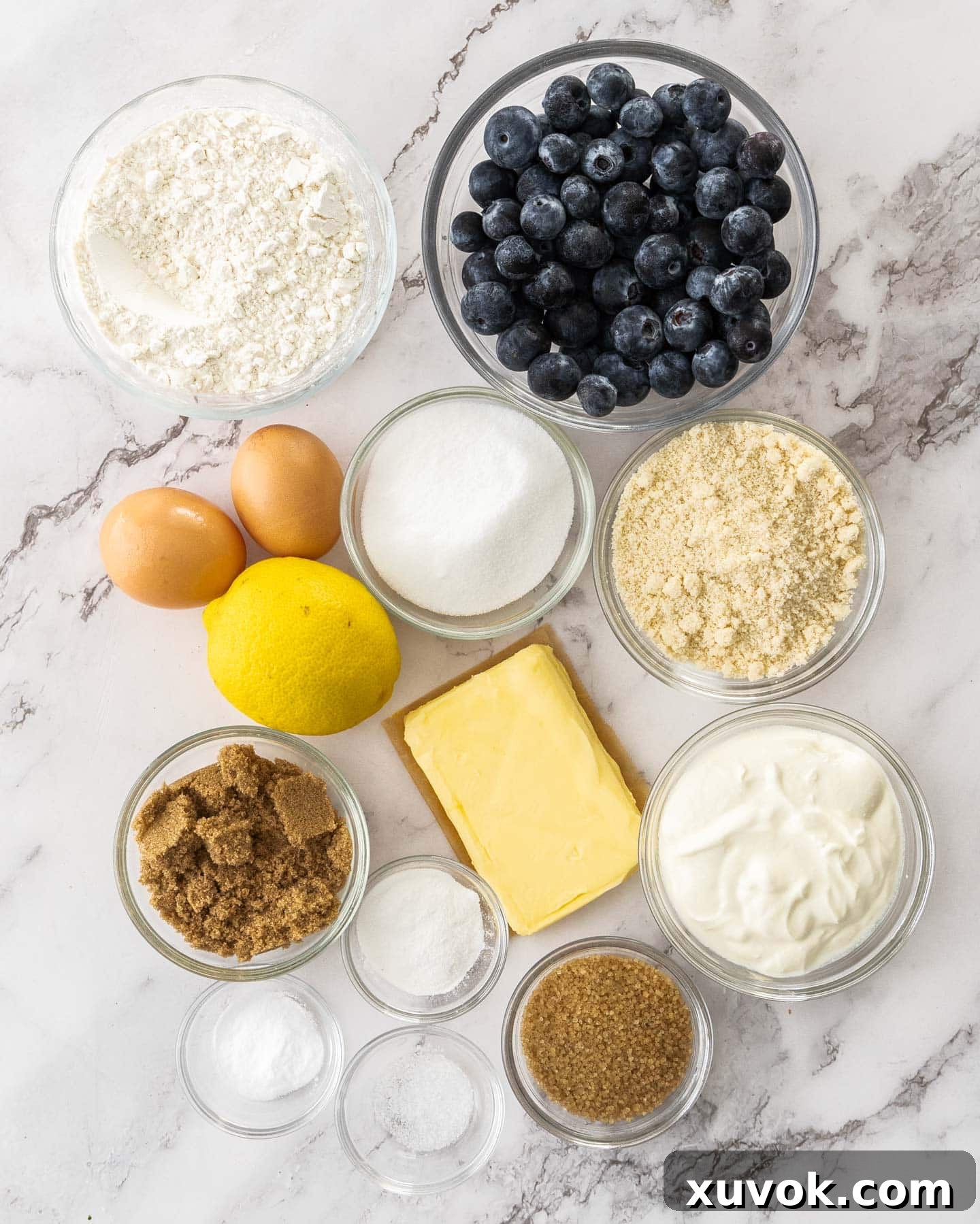 Ingredients for blueberry sour cream cake on a marble surface.