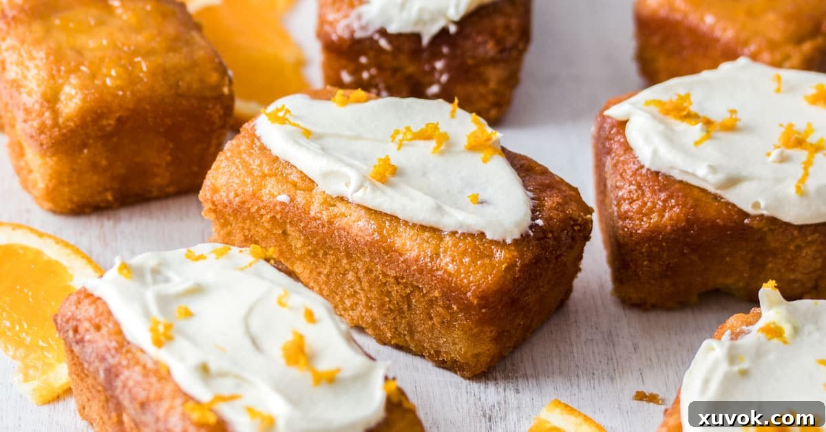 Closeup of Mini Flourless Ginger Orange Cakes on a white board, showing texture and frosting detail.