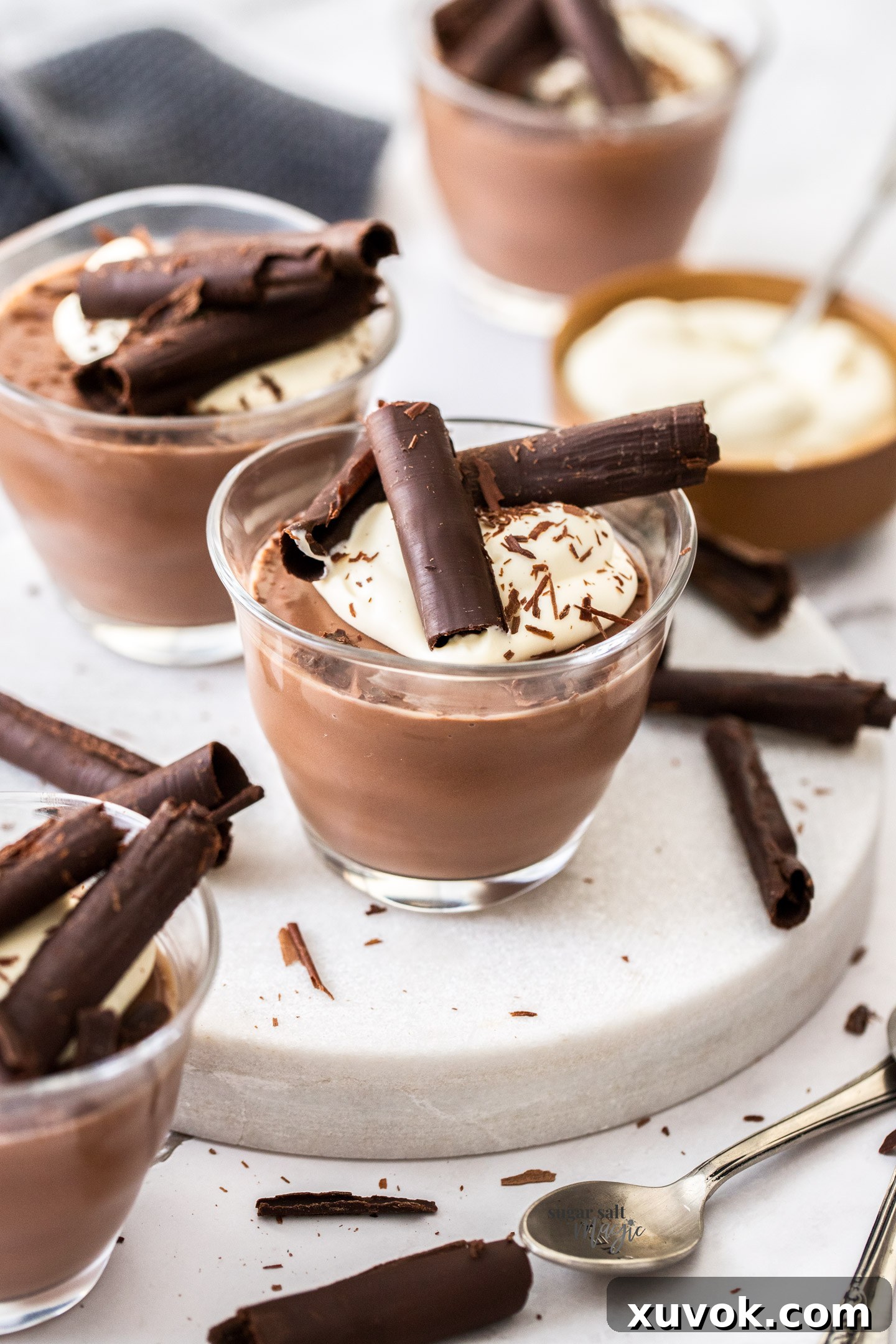 Chocolate pots topped with cream and chocolate curls.