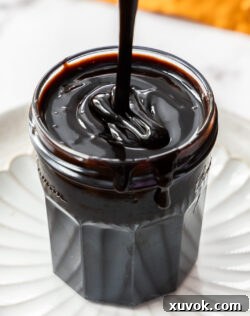 Chocolate sauce being drizzled into a jar.