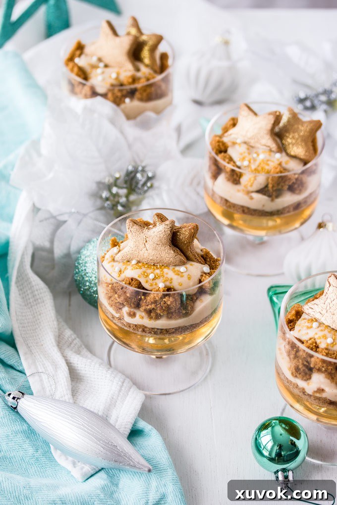 4 Gingerbread Trifle next to some green, white and silver Christmas ornaments. A stunning layered dessert ready for the holidays.
