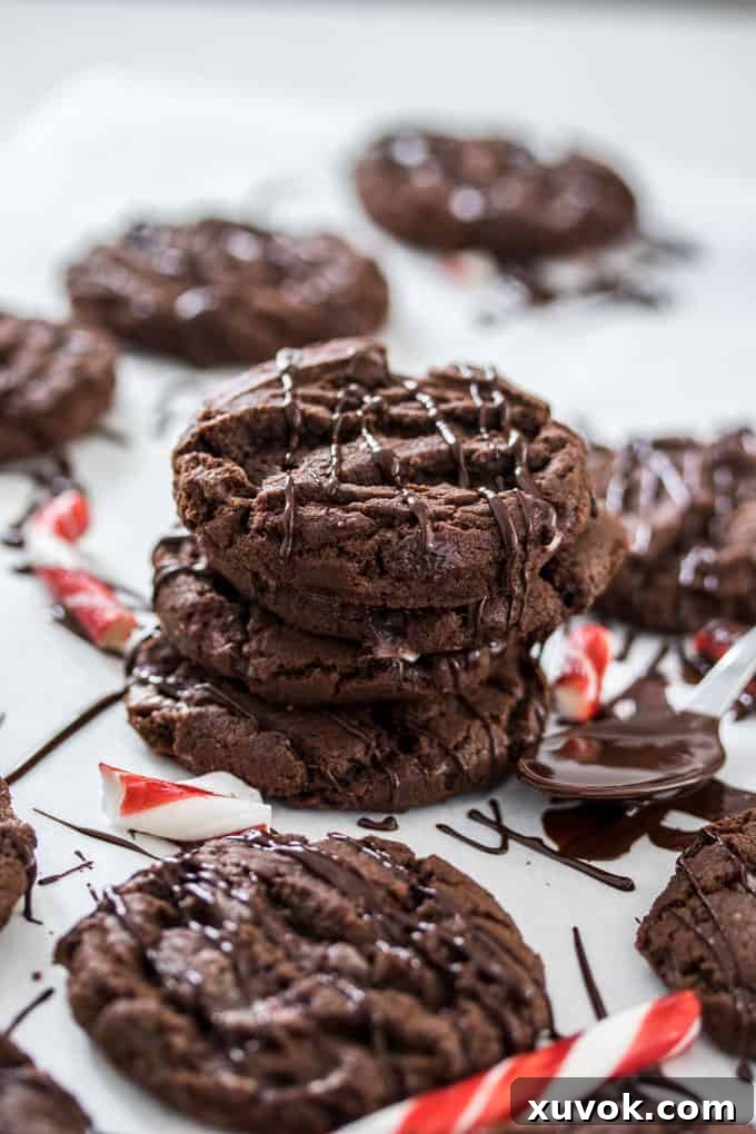 A stack of chocolate cookies surrounded by candy canes and melted chocolate drizzle.