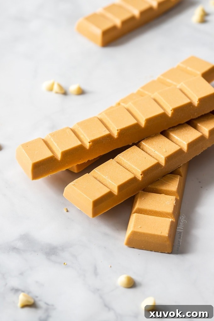A stack of blocks of caramelised white chocolate with white chocolate chips scattered around.