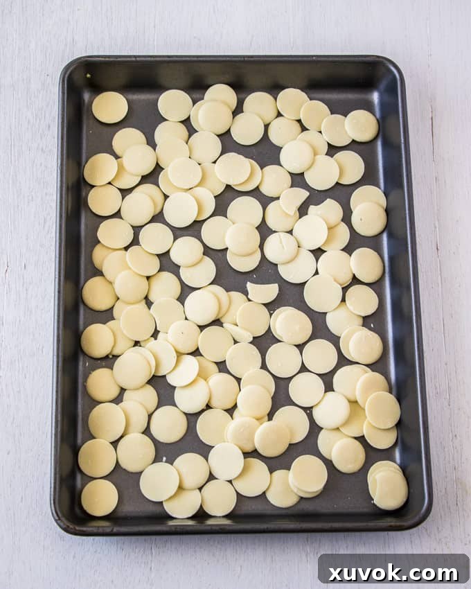A baking tray covered with large white chocolate chips, ready for caramelisation.