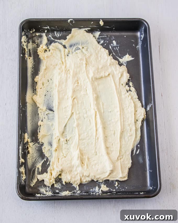 A baking tin covered in melted chocolate that is being caramelised, showing early stages of melting.