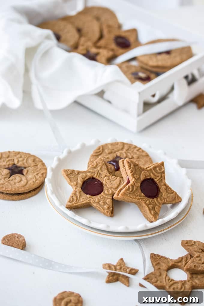 3 jam speculaas cookies on a white plate with more in a tray behind