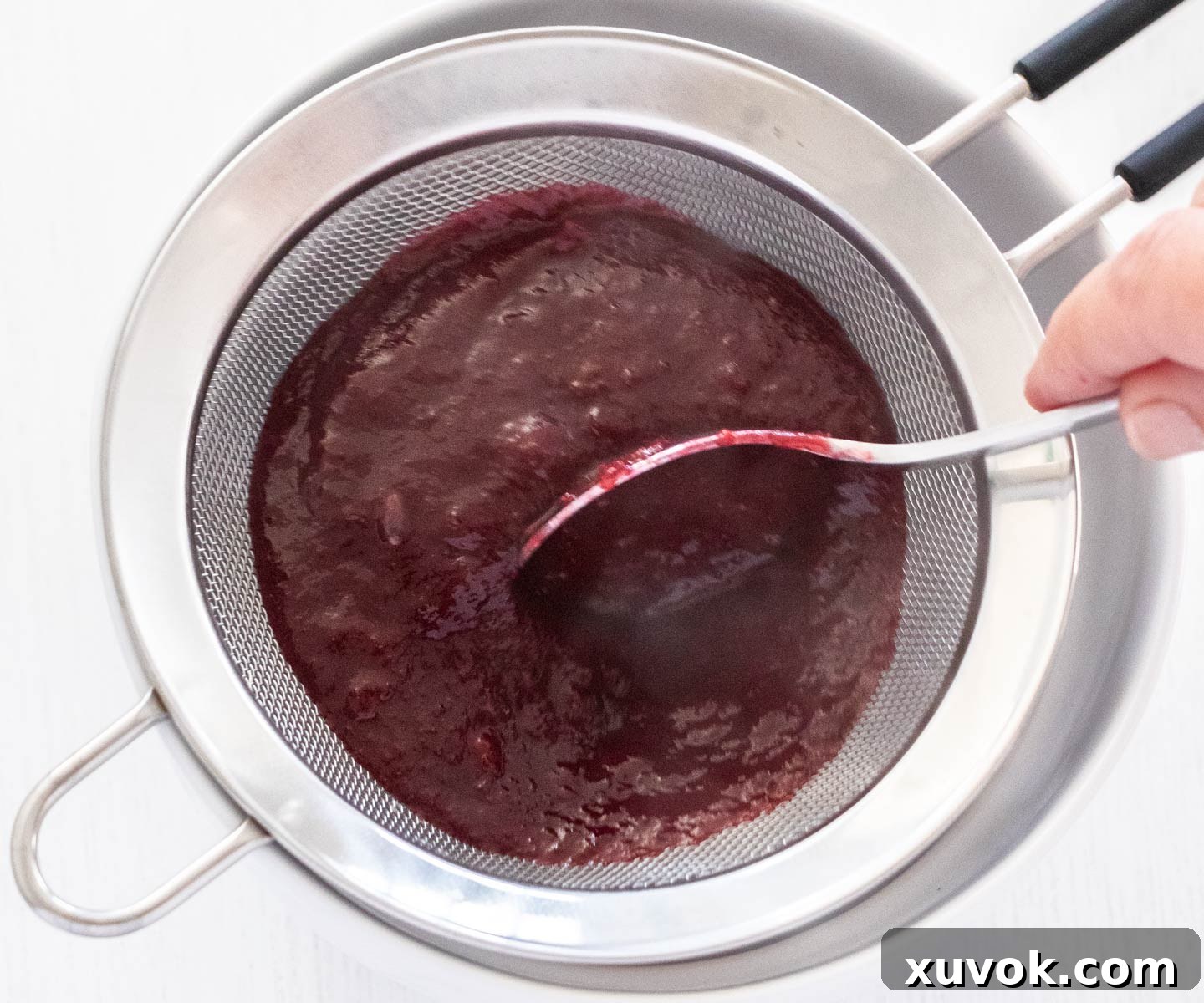 Straining the cherry sauce.