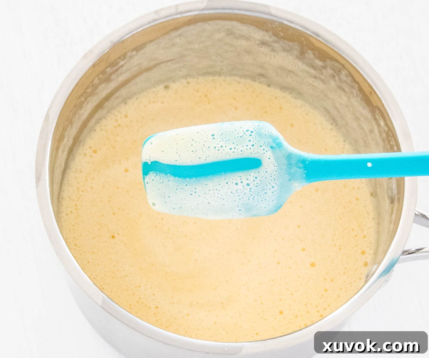 Showing the thickness of the custard on the back of a spoon.