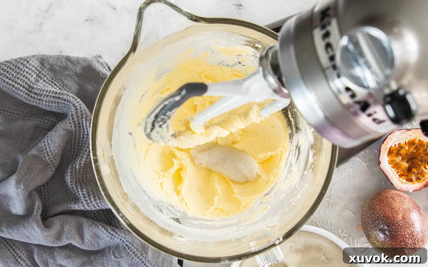 Adding the cooled flour paste, spoonful by spoonful, to the beaten butter and sugar mixture for the buttercream.