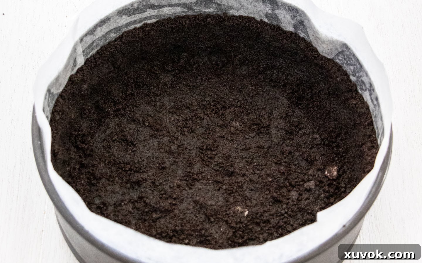 The dark chocolate Oreo cookie crust pressed firmly into an 8-inch springform pan, ready for the filling.