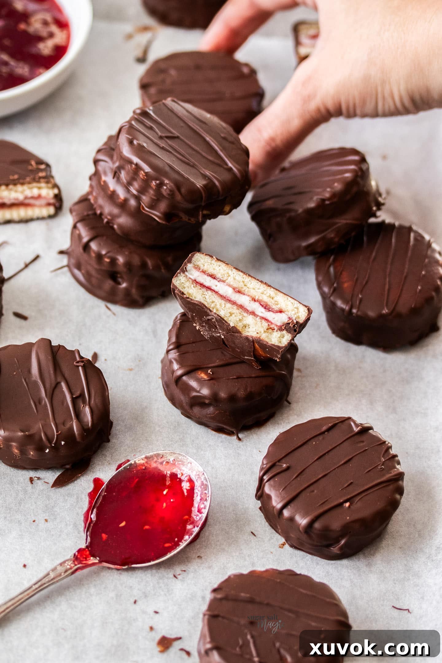 A batch of mini wagon wheels beautifully arranged, with a hand reaching in to grab one in the background.