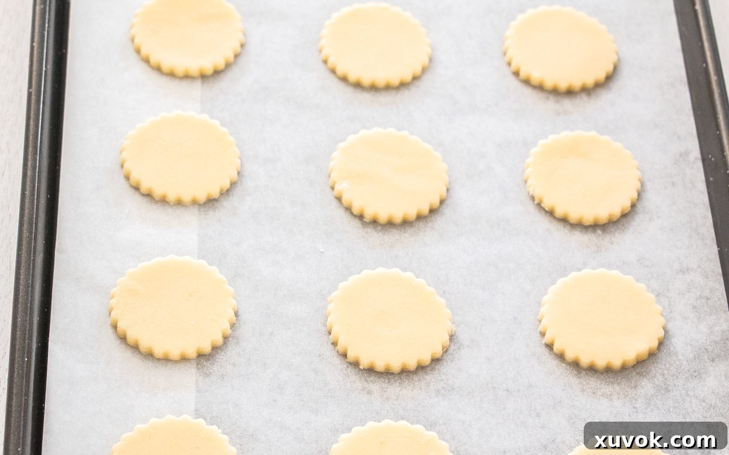 Rounds of cookie dough perfectly arranged on a baking tray, ready for the oven.
