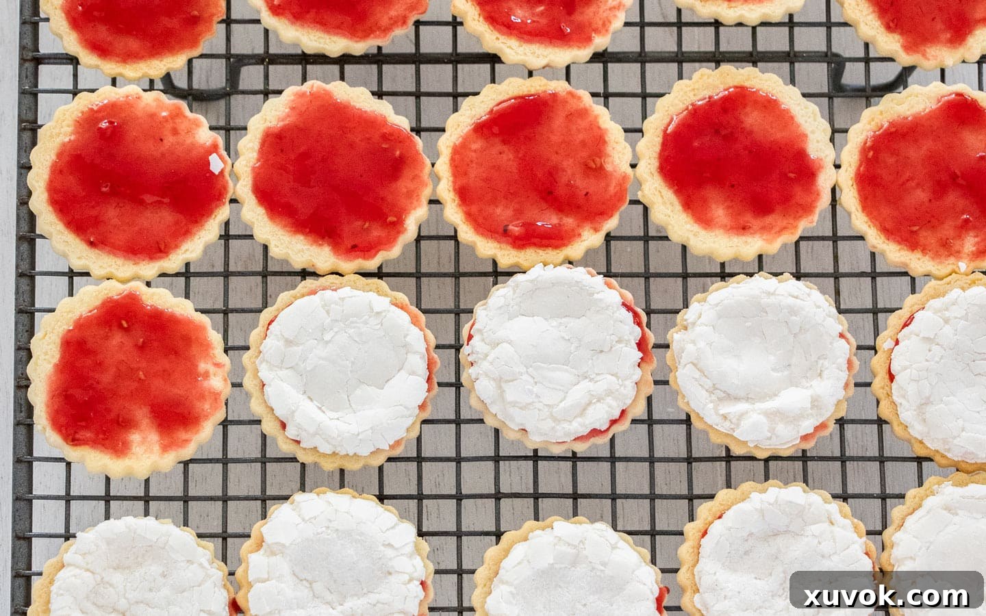 Cookies topped with jam and rolled marshmallows, ready for the second cookie layer.