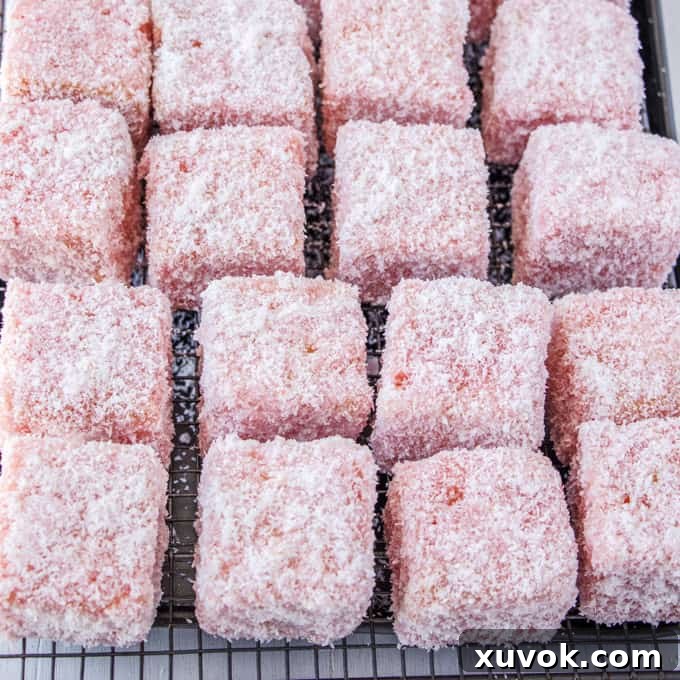 Rose Strawberry Lamingtons resting on a wire rack