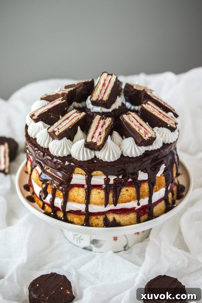 A stunning Wagon Wheel Cake, generously decorated with mini Wagon Wheels, proudly displayed on a beautiful cake stand. The layers of sponge, jam, and frosting are visible, creating an inviting visual treat.