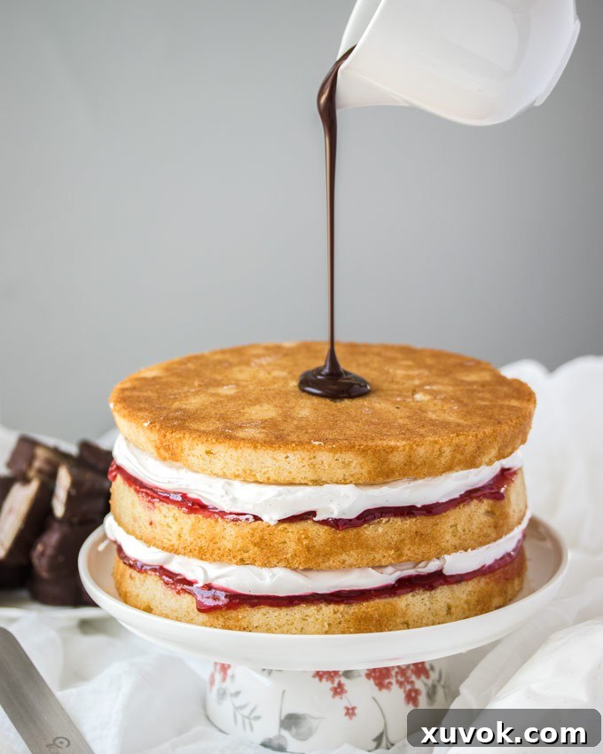 Rich, glossy chocolate ganache being poured gracefully over the top of a beautifully assembled three-layer cake, creating an enticing drip effect down the sides.