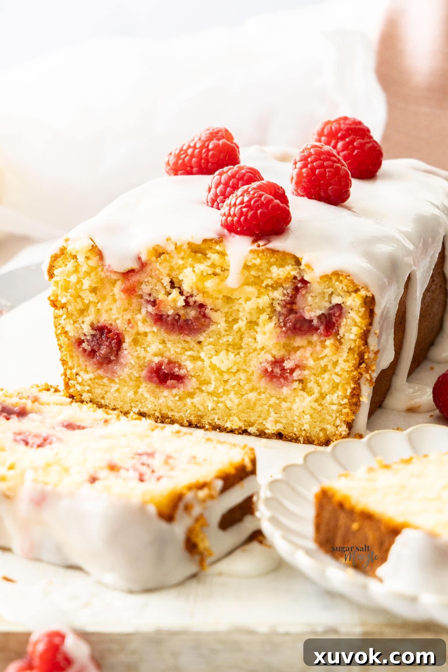 Closeup of the inside texture of a moist raspberry lemon loaf, showing berries and lemon zest.