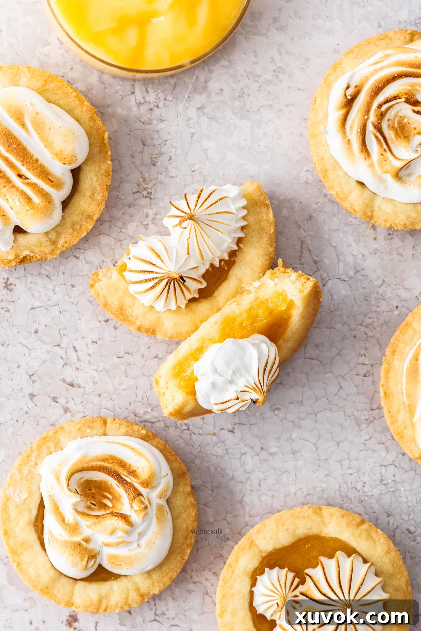 Top down view of a lemon meringue pie cookie broken in half, revealing the soft filling.