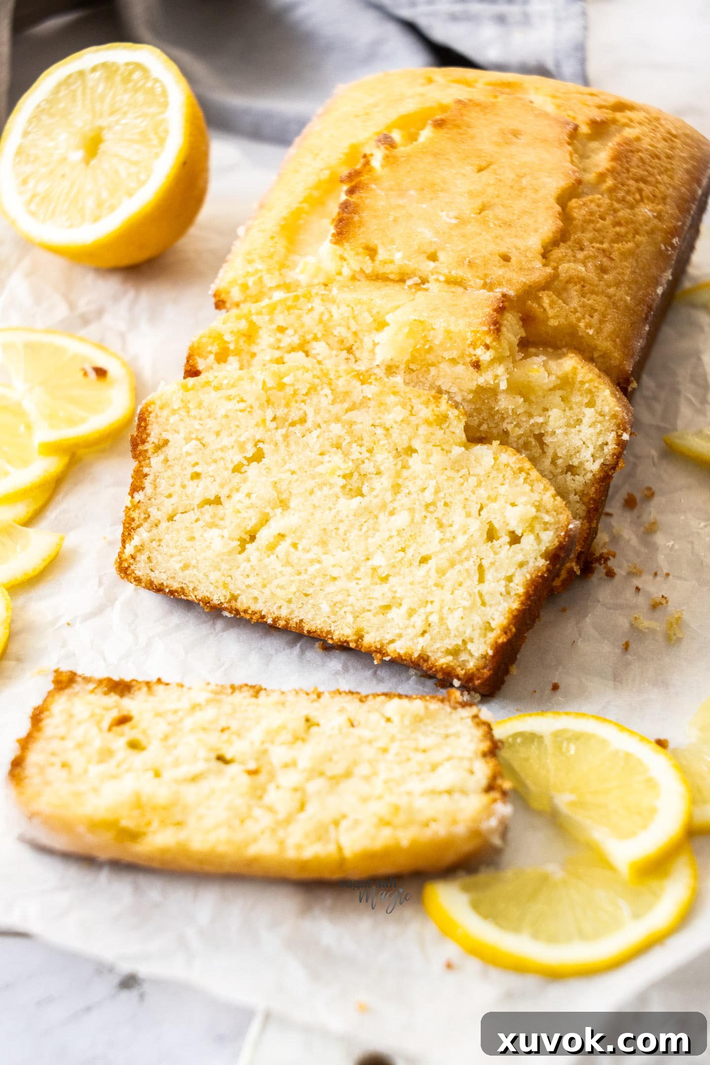 Slices of lemon drizzle cake leaning up against the remaining loaf.