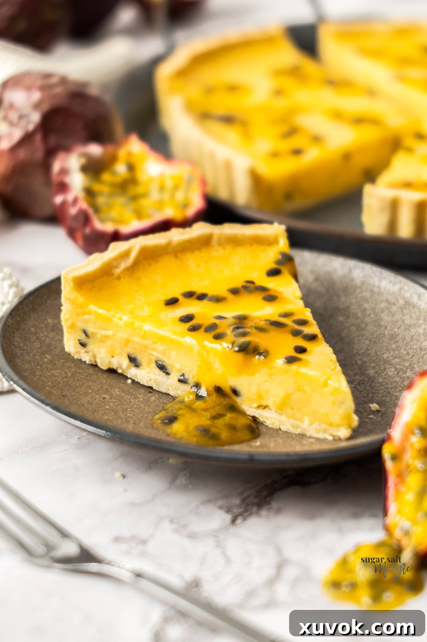 A slice of passionfruit tart on a small dessert plate.