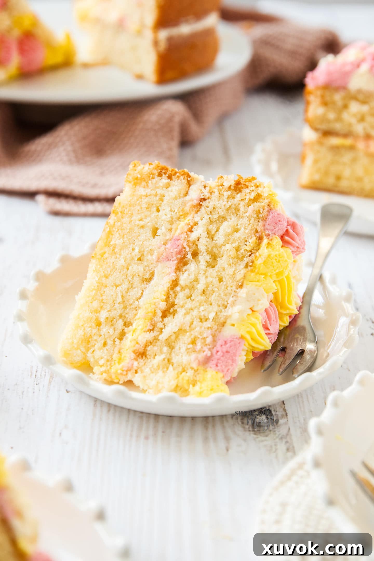 A slice of fluffy vanilla cake on a dessert plate.