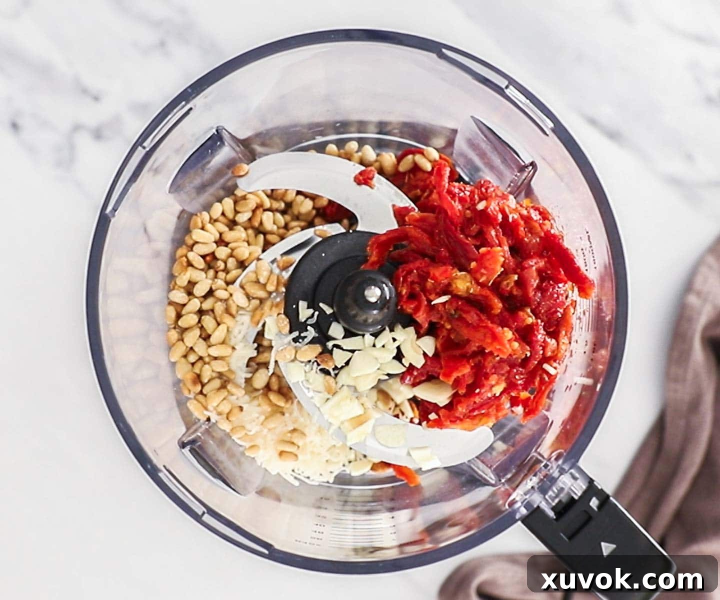 Ingredients for sundried tomato pesto in a food processor bowl.