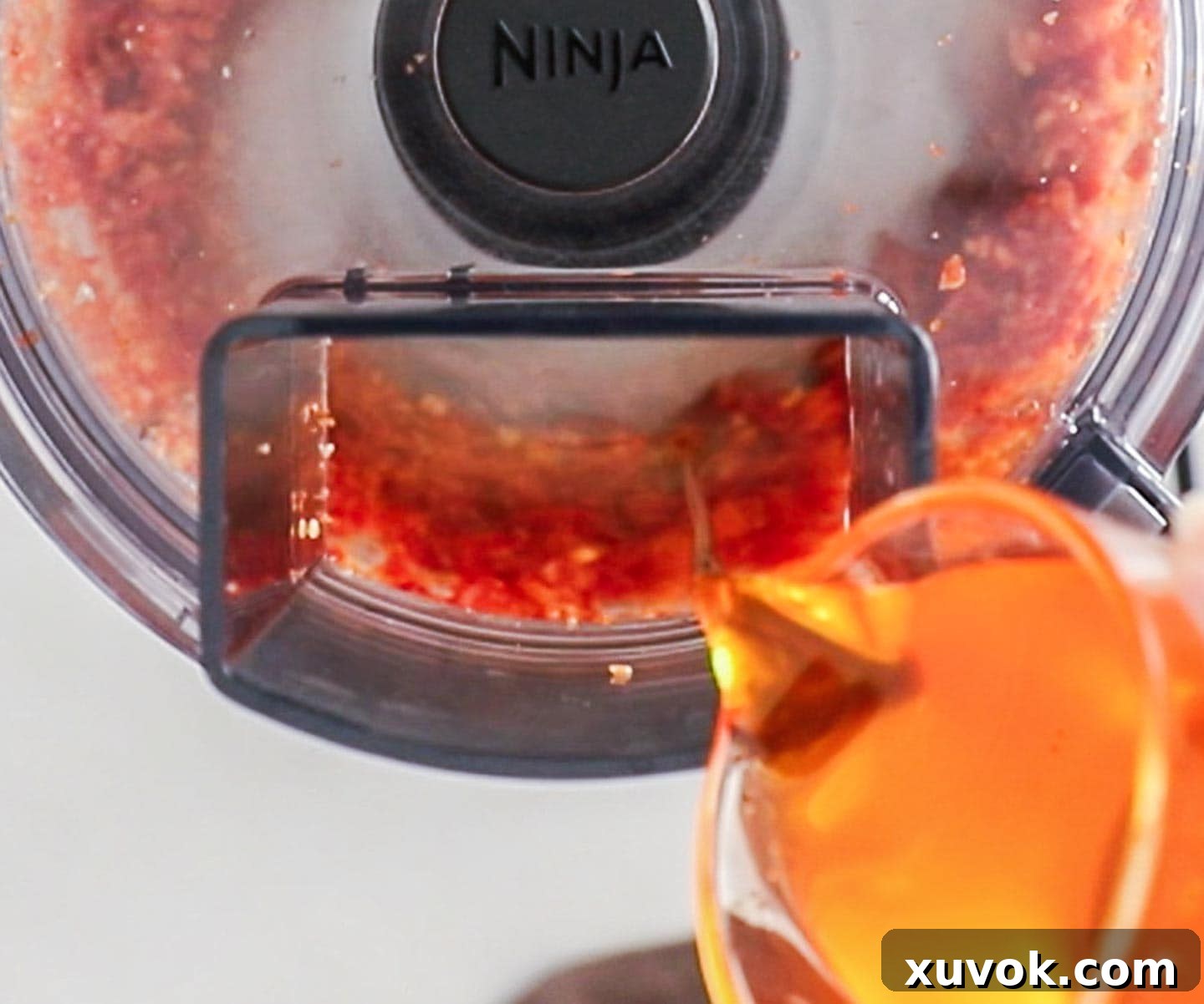 Pouring oil into a food processor.